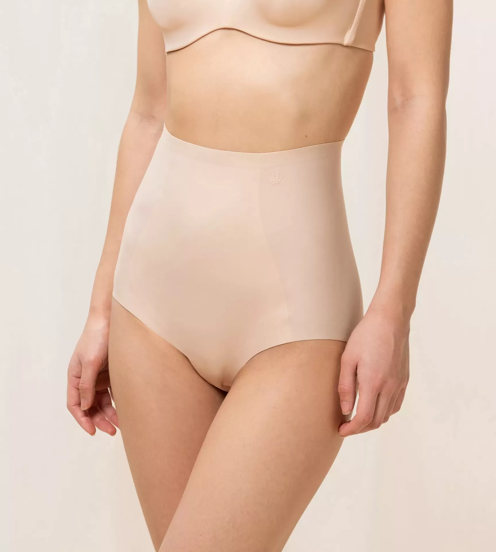 Calcinha bege de cintura alta em tecido liso usada por modelo