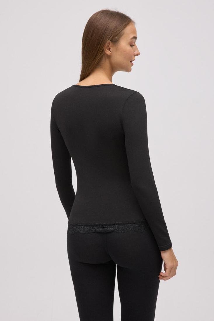 Pessoa de costas com roupa preta de manga comprida e leggings com renda