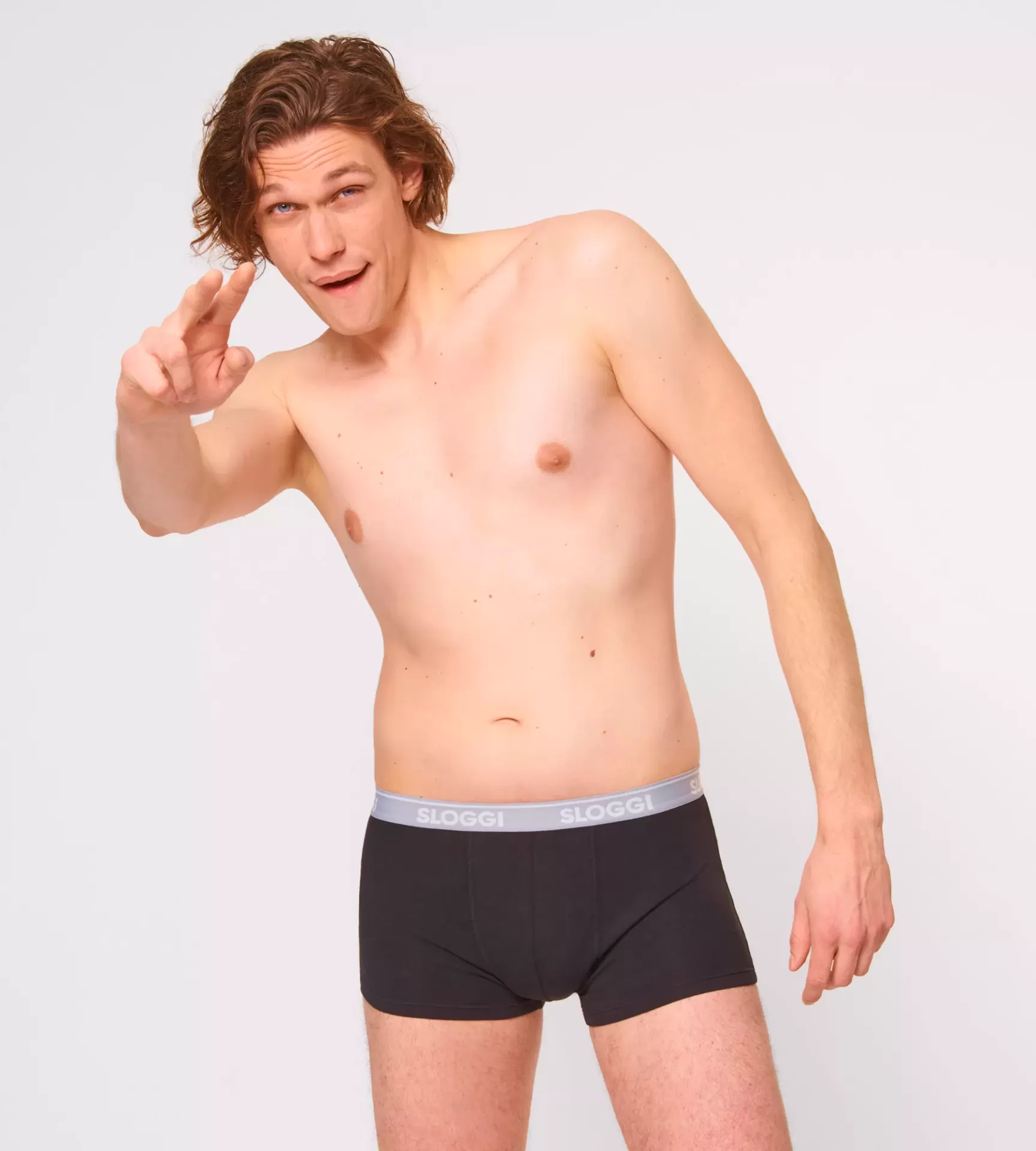 Homem com cueca boxer preta e cós cinza com a marca SLOGGI