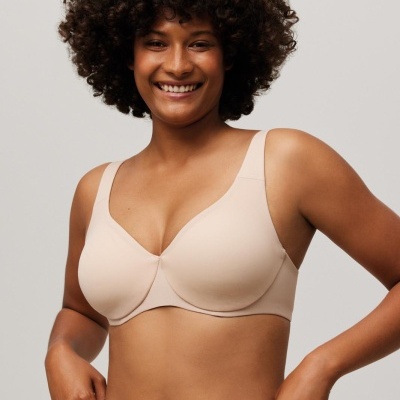 Soutien bege claro de tecido liso com alças largas, usado com cuecas altas, sem padrões, em fundo cinza claro