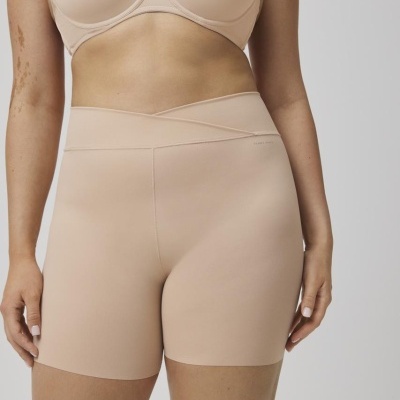 Mulher com sutiã e calção curtos bege