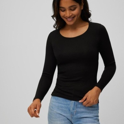 Pessoa com t-shirt preta de manga comprida e calças de ganga azuis claras