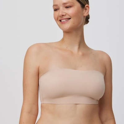 Mulher a usar top bandeau e cuecas cor de pele sobre fundo branco