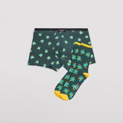 Conjunto de roupa interior e meias com padrão tropical amarelo e azul em fundo preto