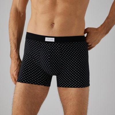 Cuecas boxer pretas com padrões brancos e etiqueta PAUL JONES na cintura, usadas por modelo masculino sem camisa