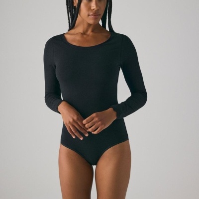 Body feminino preto de manga comprida com decote redondo em fundo cinzento