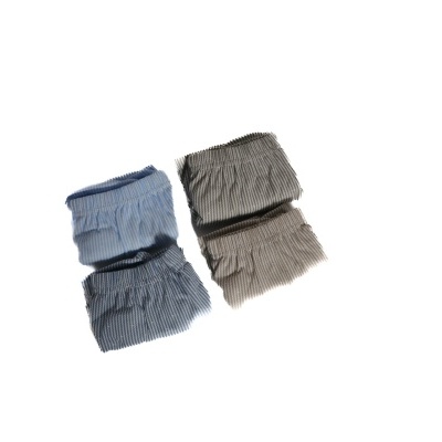 Quatro fraldas de tecido riscado azul e bege sobre fundo branco