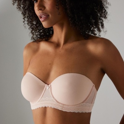 Soutien rosa claro sem alças com renda usado por modelo