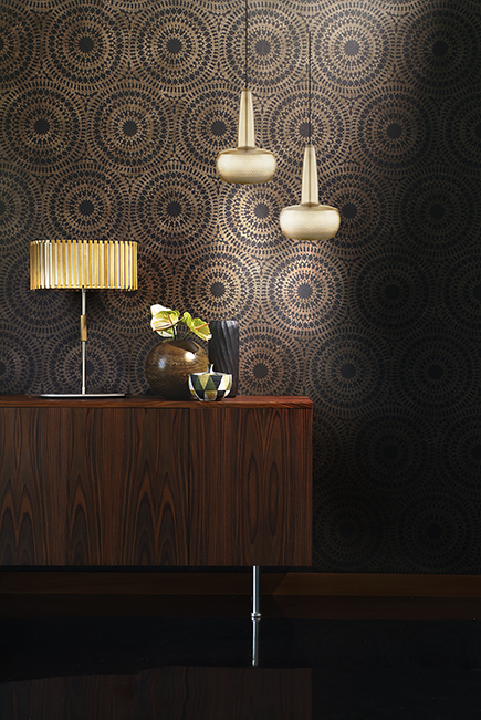 CLAVA Aparelho de mobiliário de madeira escura com abajur dourado e vasos sobre ele, contra parede com padrão circular preto e dourado