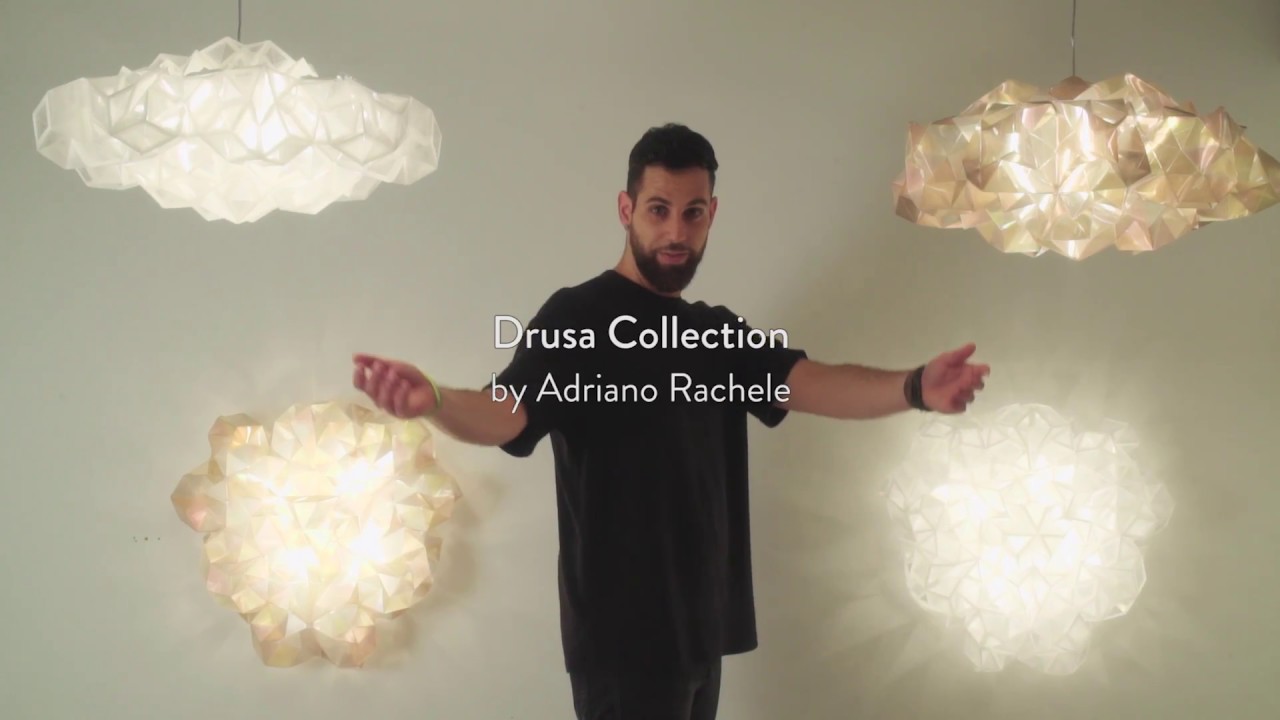 DRUSA Homem entre quatro luminárias pendentes geométricas em tons branco e bege