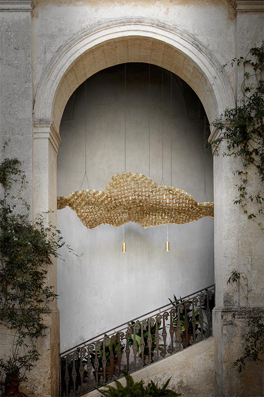 NUVEM Veludo Suspensão luminária dourada decorativa numa entrada com arco de pedra e escada