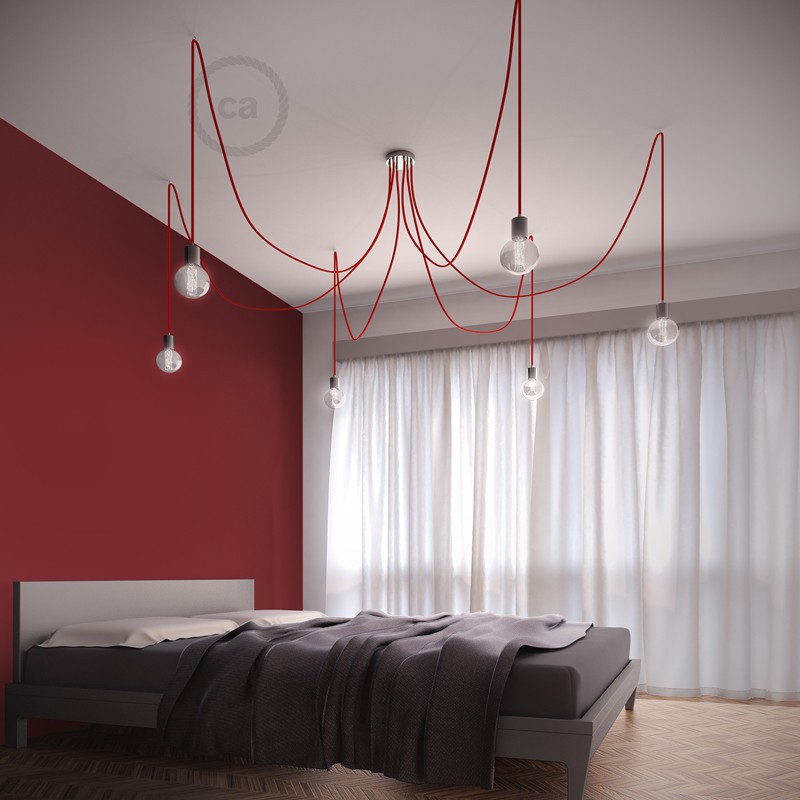 ARANHA 5 | 6 | 7 CROMADO | VERMELHO Quarto moderno com cama cinza, parede vermelha e luminárias com fios vermelhos no teto.