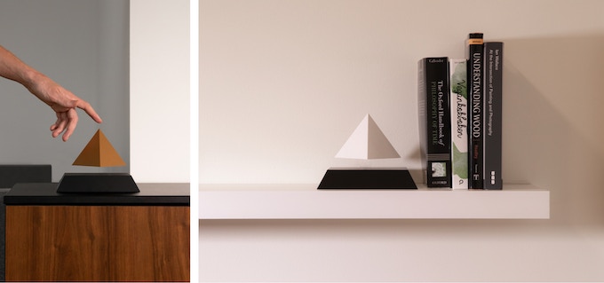 FLYTE PY Duas pirâmides decorativas, uma castanha e outra branca, sobre móveis em madeira e prateleira branca ao lado de livros.