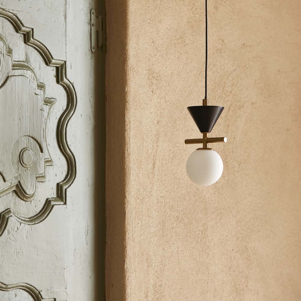 ONETA Lustre suspenso com bola branca e cone preto junto a uma porta cinzenta decorativa