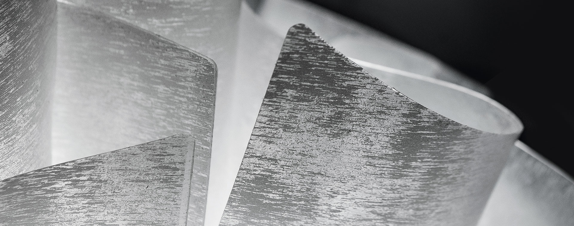 VELI COUTURE wall Lâminas metálicas curvas e sobrepostas com textura riscada em imagem a preto e branco