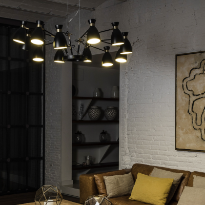 Sala de estar com sofá castanho, mesa de madeira, candeeiro moderno e parede de tijolo branco