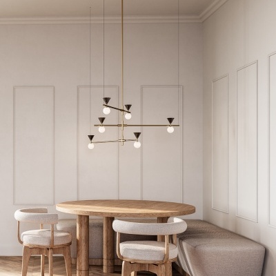 Área de jantar com mesa redonda de madeira, cadeiras estofadas bege e sofá em tecido cinza, parede branca e candeeiro suspenso moderno dourado.