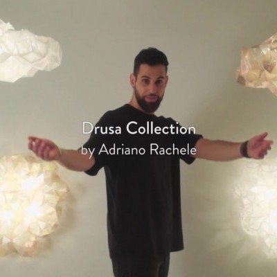 Homem entre quatro luminárias pendentes geométricas em tons branco e bege