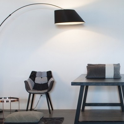 Conjunto de lâmpada de pé, cadeira, mesa e almofadas em ambiente minimalista