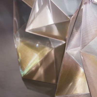 Objeto decorativo translúcido com faces triangulares em tons claros