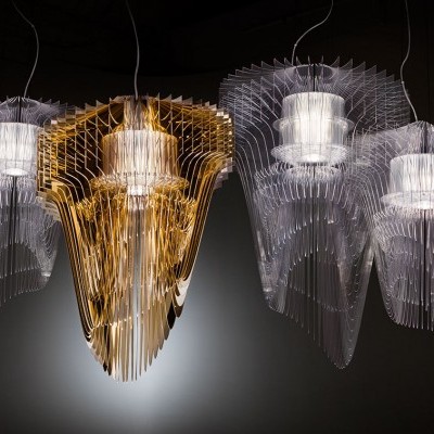 Quatro candeeiros suspensos modernos em rede, três transparentes e um dourado no centro.