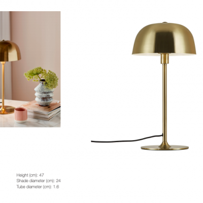 Candeeiro de mesa dourado com cúpula arredondada sobre mesa com decoração