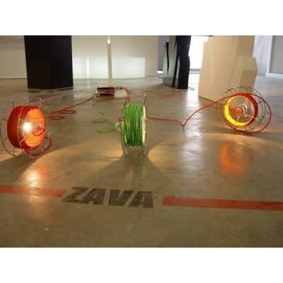 Três carretéis de fios industriais com fios coloridos e chão com inscrição ZAVA