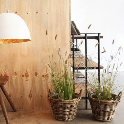Candeeiro branco pendurado, banco de madeira, duas plantas em vasos de vime e estrutura metálica preta