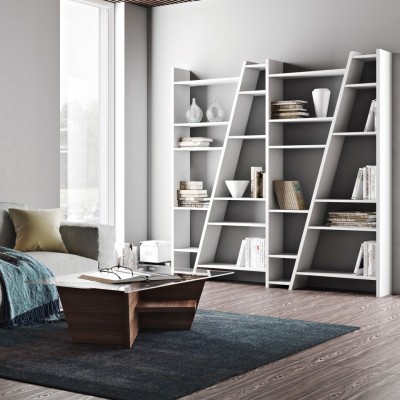 Estante branca moderna com livros e objetos decorativos numa sala contemporânea com sofá cinza e mesa de centro escura