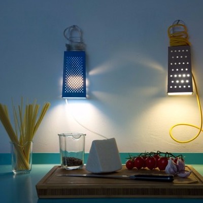 Lâmpadas decorativas azuis e amarelas em forma de ralador de queijo com comida numa mesa