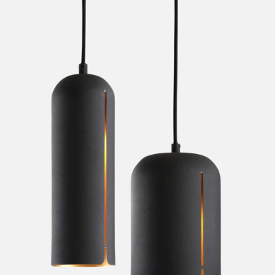 Dois candeeiros industriais suspensos pretos cilíndricos com aberturas verticais com luz interior amarela