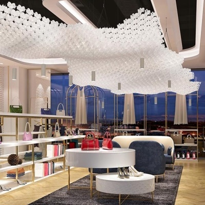 Loja moderna de acessórios com bolsas e sapatos expostos em estantes e mesas sobre tapete