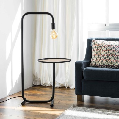 Mesa auxiliar preta com lâmpada e sofá azul com almofada colorida