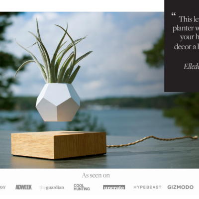 Vaso levitante branco com base de madeira e planta artificial ao ar livre