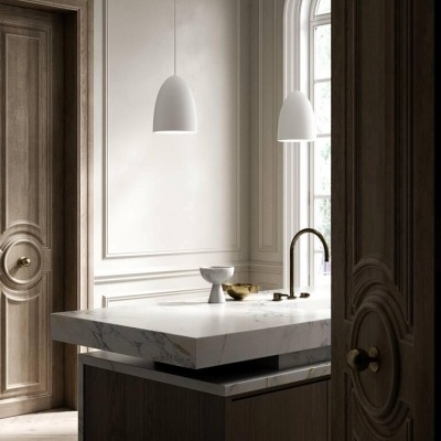 ilha de cozinha em mármore branco e armários de madeira escura com candeeiros pendentes brancos