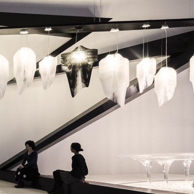 Interior moderno e minimalista com luminárias pendentes em forma de folhas brancas e pessoas sentadas