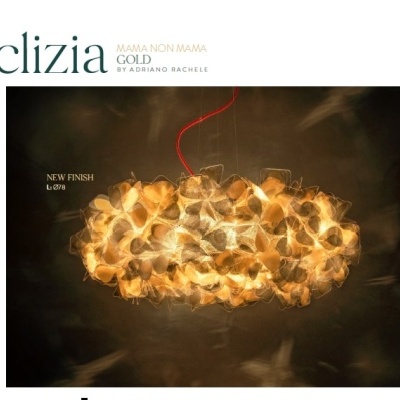 Luminária pendente dourada com pétalas iluminadas em ambiente escuro