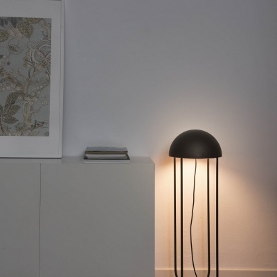 Candeeiro de chão preto ao lado de móvel branco numa sala