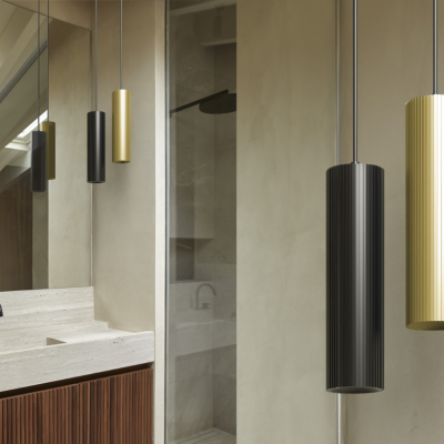 Candeeiros suspensos cilíndricos preto e dourado numa casa de banho moderna