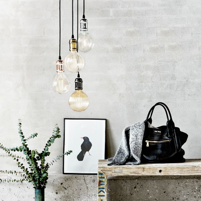 Lâmpadas pendentes, bolsa preta, decoração com planta e quadro de pássaro