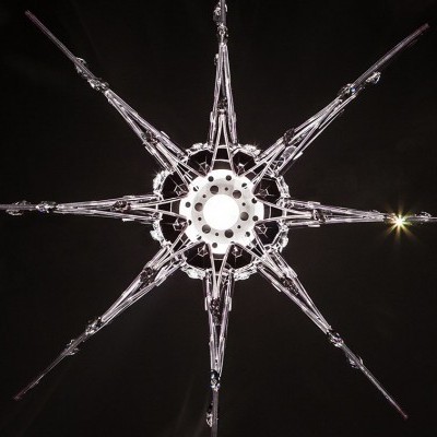 Decoração em forma de estrela em vidro translúcido com oito pontas e fundo preto