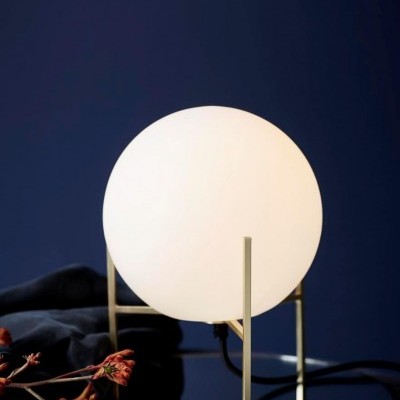 Candeeiro de mesa esférico branco com estrutura dourada sobre base espelhada