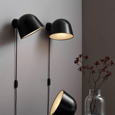 Três candeeiros pretos e vaso transparente com flores secas vermelhas