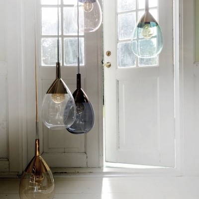 Candeeiros suspensos em vidro translúcido em formato de gota junto a porta branca