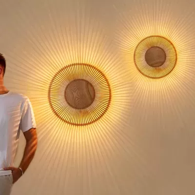 Dois candeeiros de parede redondos em madeira e metal com padrão de luz