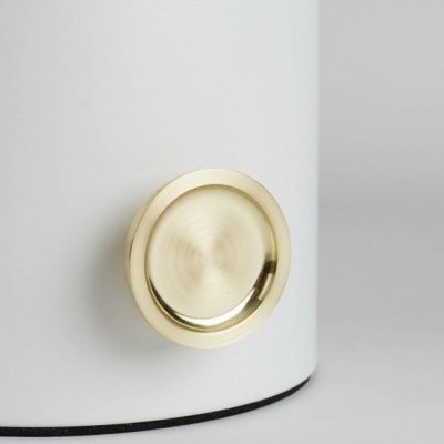 Torneira ou válvula redonda dourada numa superfície branca