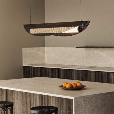 Luminária suspensa preta moderna sobre bancada de cozinha com prato de laranjas