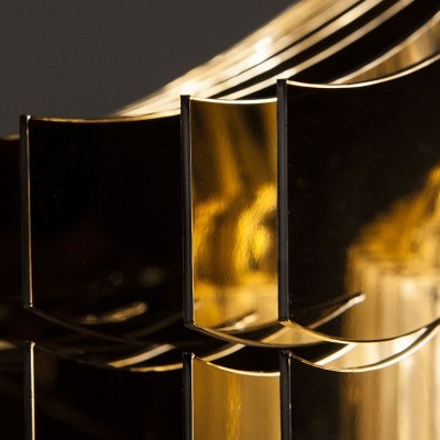 Luminária metálica dourada com lâmpadas visíveis num padrão geométrico