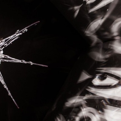 Obra com estrela metálica ou de vidro e texto branco desfocado sobre fundo escuro