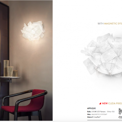 Lâmpada de parede branca junto a cadeira vermelha refletida em espelho oval